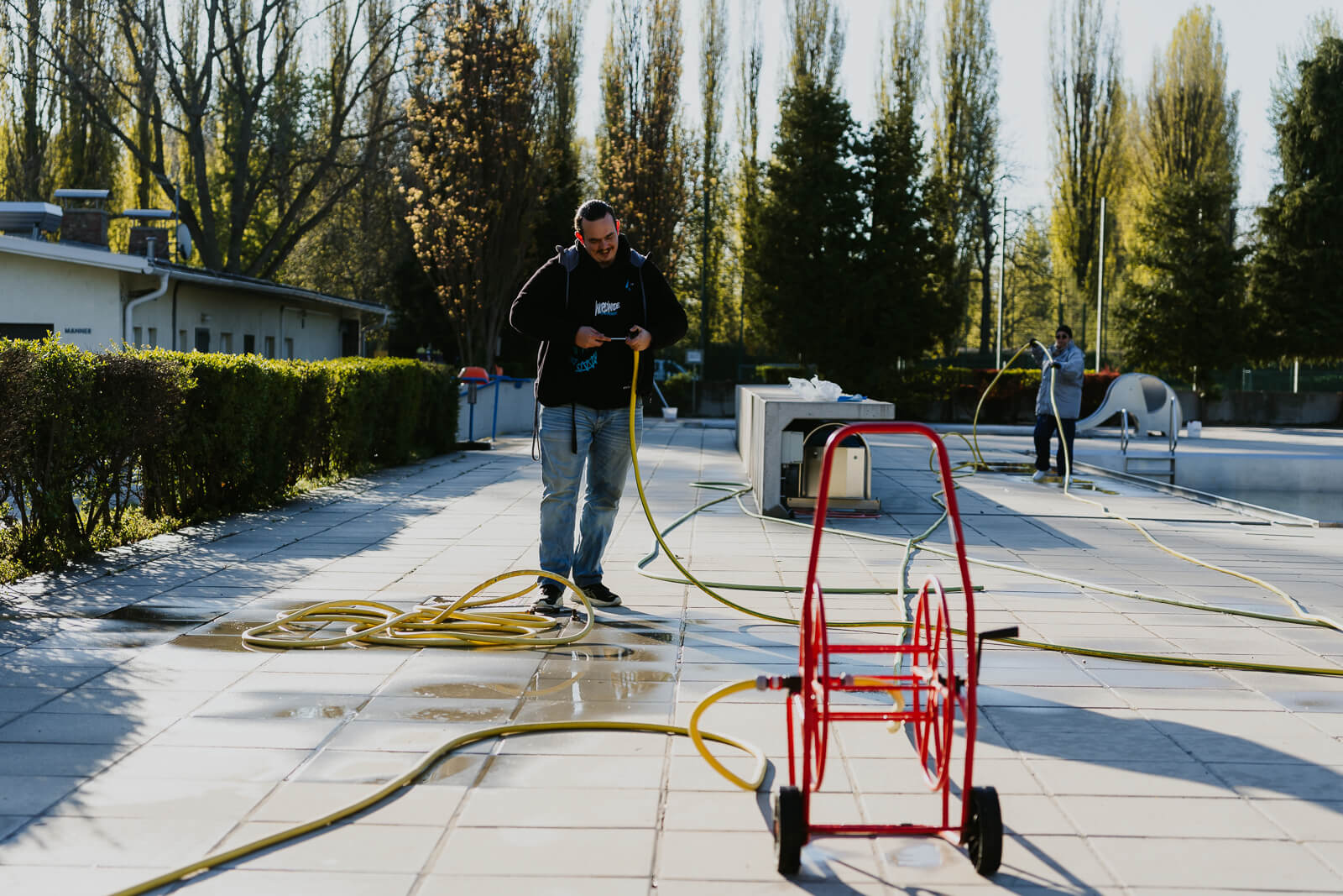 Mann arbeitet mit Wasserschlauch. Strandbad Alte Donau Wien, Fotoprojekt, Fotoreportage