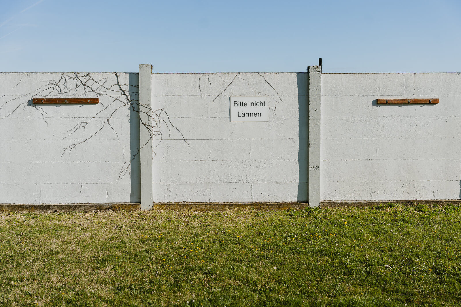 Wand des Sonnenbads im Strandbad Alte Donau. Darauf ist ein Schild mit Warnhinweis montiert.