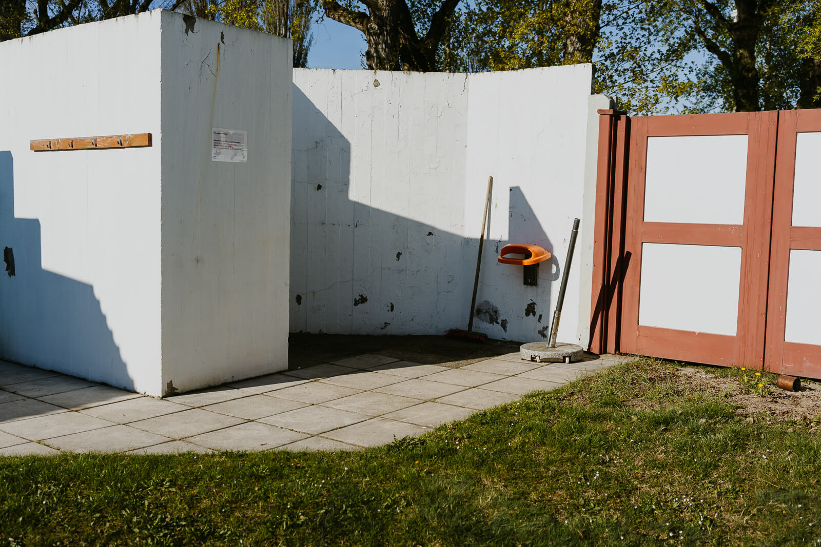Wände des Sonnenbads im Strandbad Alte Donau. Zu sehen sind Besen und der Deckel eines Mistkübels.