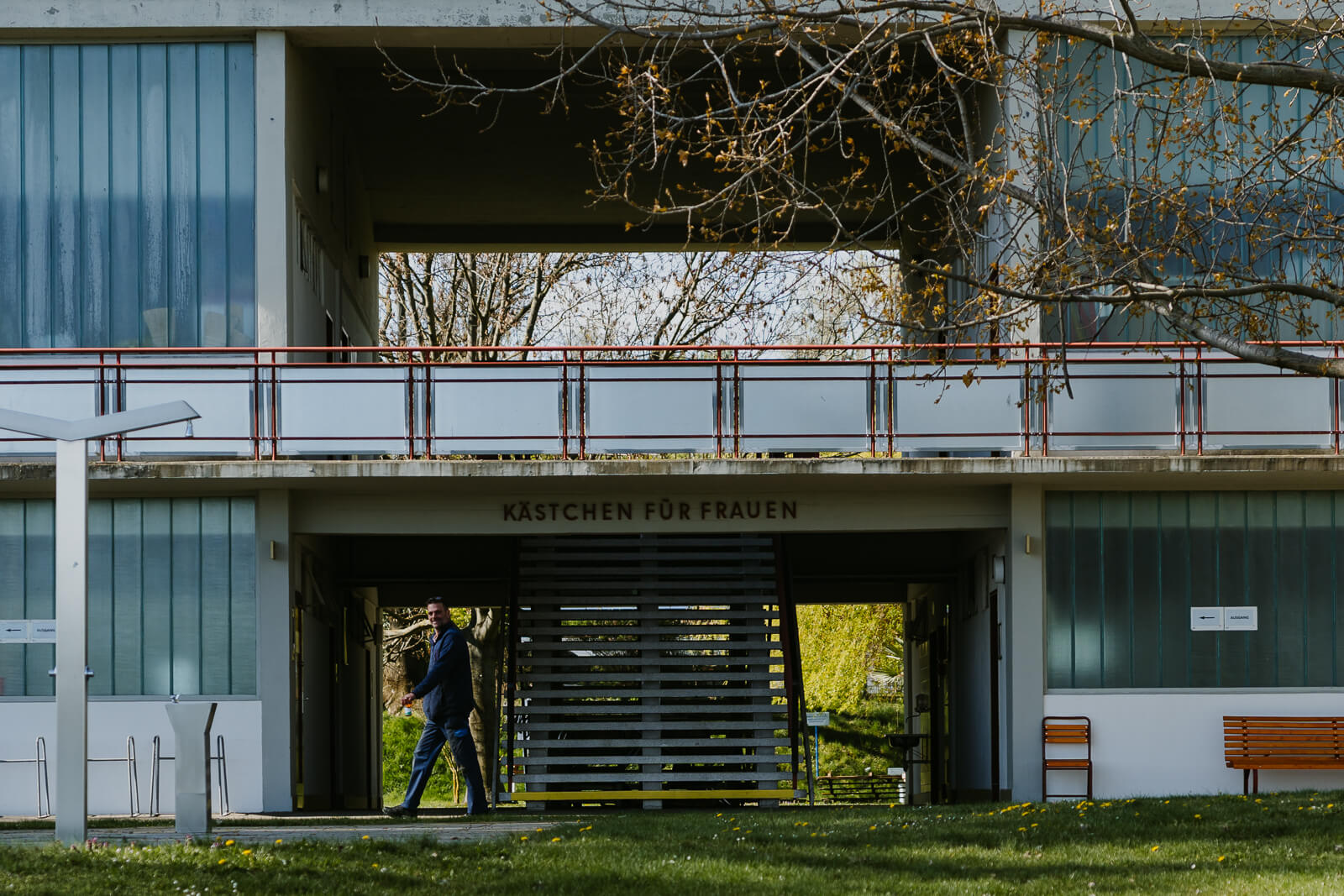 Außenansicht des Badehauses im Strandbad Alte Donau. Mitarbeiter geht gerade den Weg entlang.