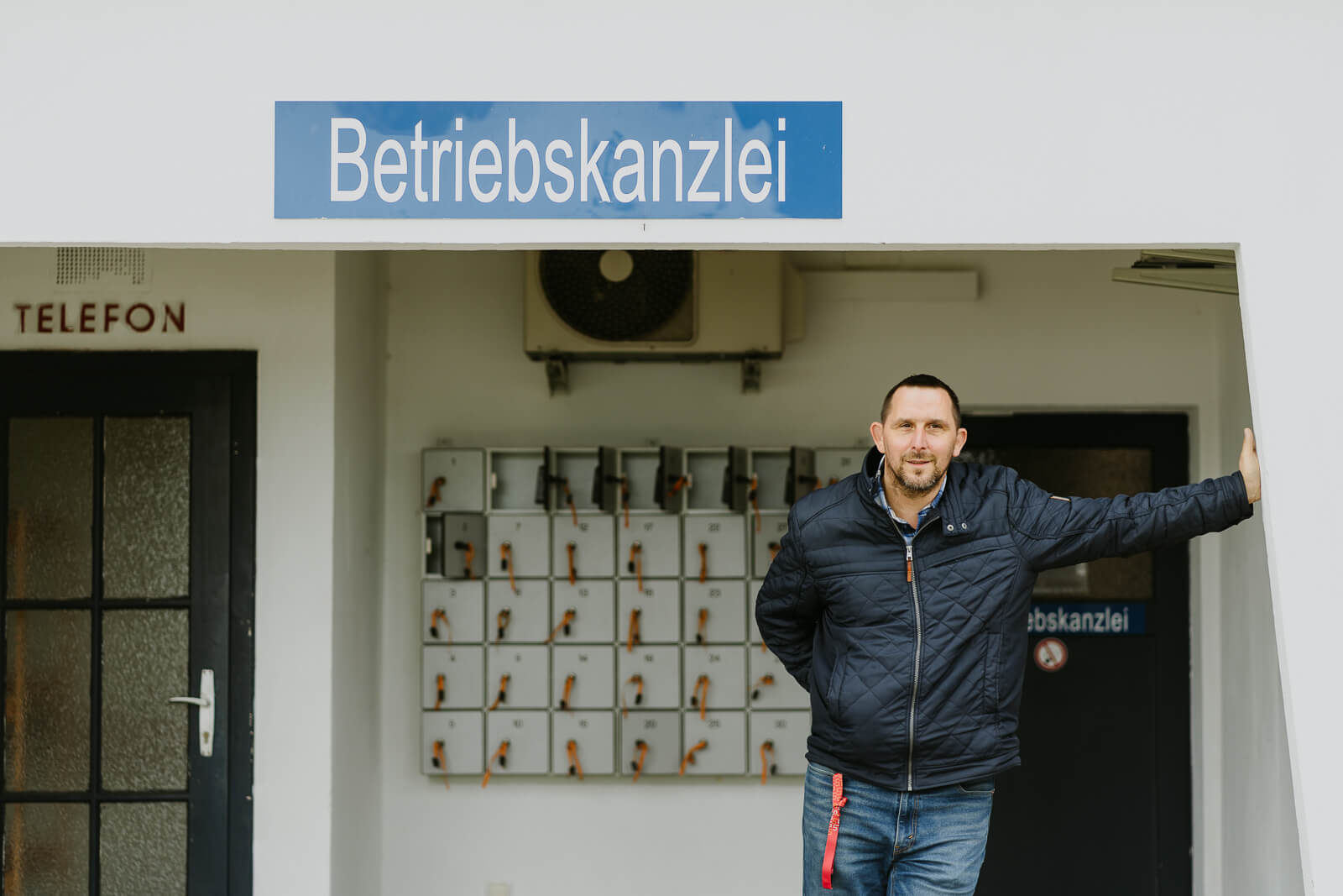 Mann leht vor Betriebskanzlei des Strandbads Alte Donau. Es handelt sich um den Leiter des Bads.