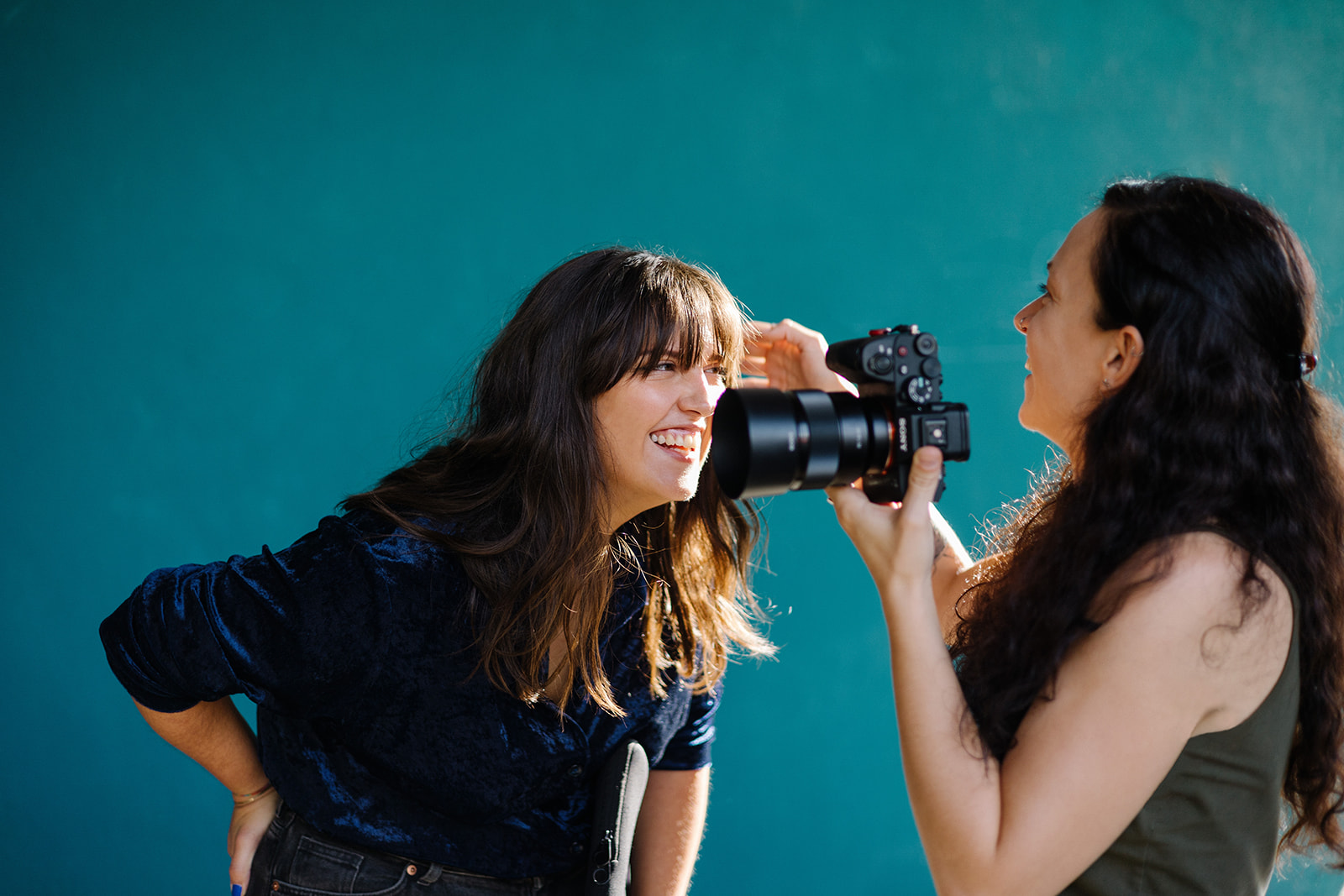 Fotografin Anna Sommerfeld fotografiert eine Kundin im Außenbereich, direkte Interaktion während des Shootings