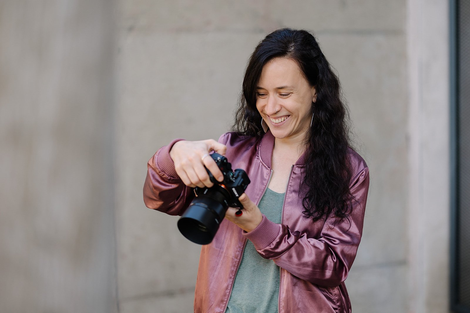 Fotografin Anna Sommerfeld prüft ihre Kameraeinstellungen, konzentrierte Vorbereitung im Shooting