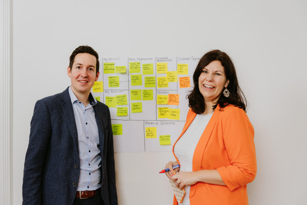 Zwei Menschen stehen vor Post it Plakat und machen gerade Brainstorming. Business und Firmenfotografie Wien und Niederösterreich