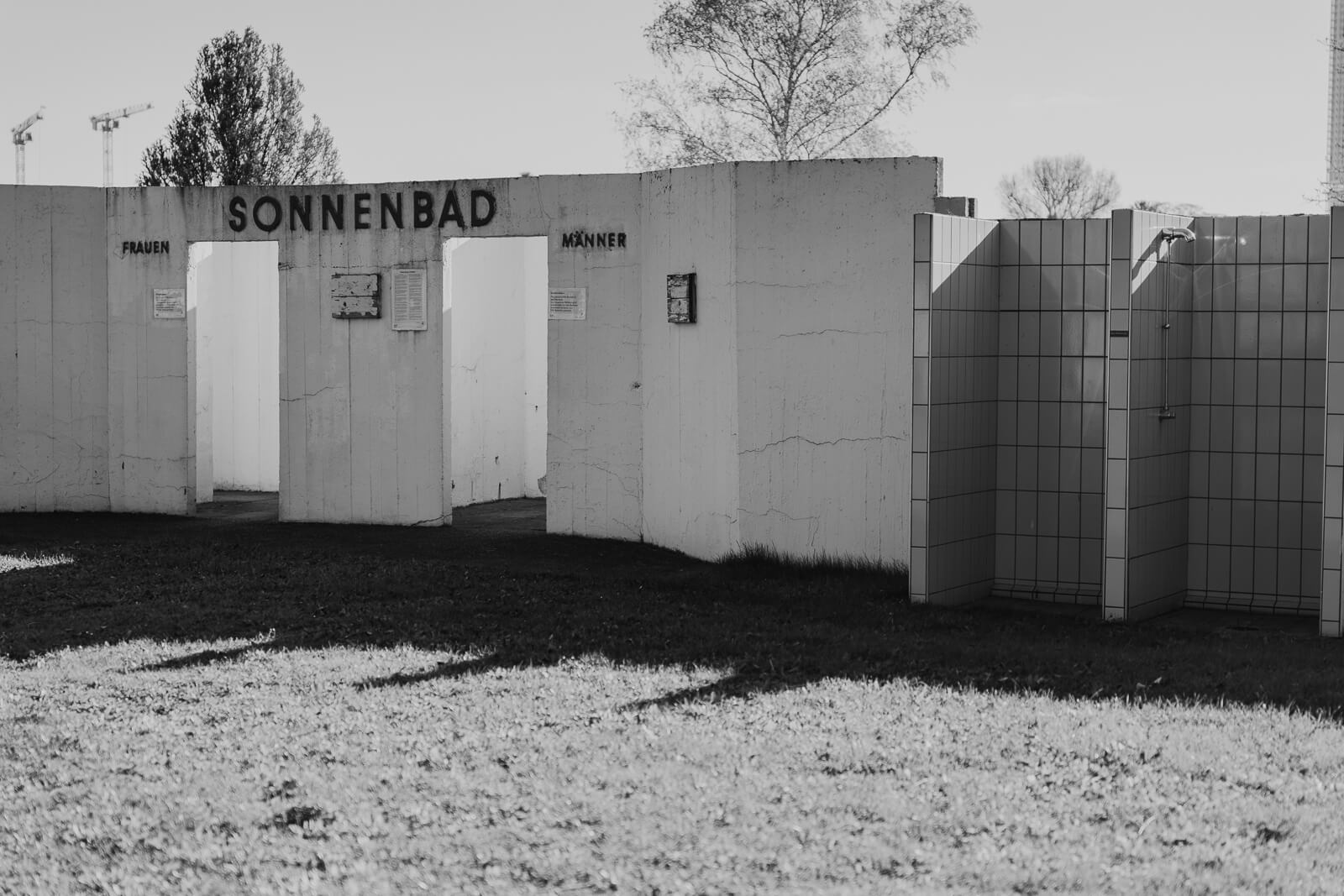 Betonwand auf der "Sonnenbad" geschrieben steht. Die Wand hat zwei Eingänge, einmal für Männer, einmal für Frauen. Fotoreportage, Fotoprojekt, Wien